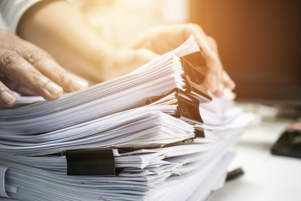 Une pile de papiers représentant les démarches administratives liées à la création d'une micro-entreprise.