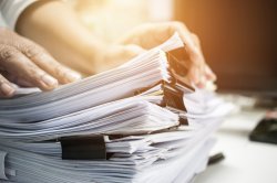 Une pile de papiers représentant les démarches administratives liées à la création d'une micro-entreprise.