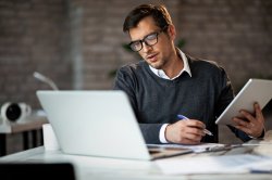 Un auto-entrepreneur travaillant sur les démarches pour ajouter une activité à son entreprise.