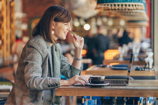 Femme micro-entrepreneuse travaillant sur son ordinateur dans un café