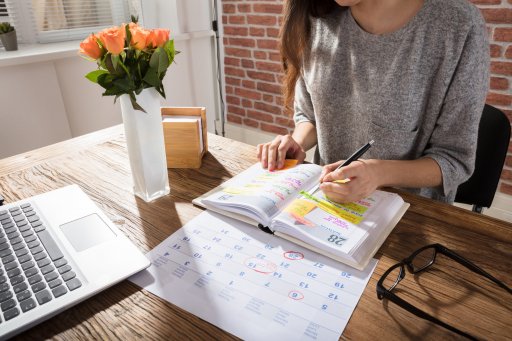 Gros Plan D'Une Femme D'Affaires Faisant Un Agenda Sur Son Organisateur Personnel Au Travail